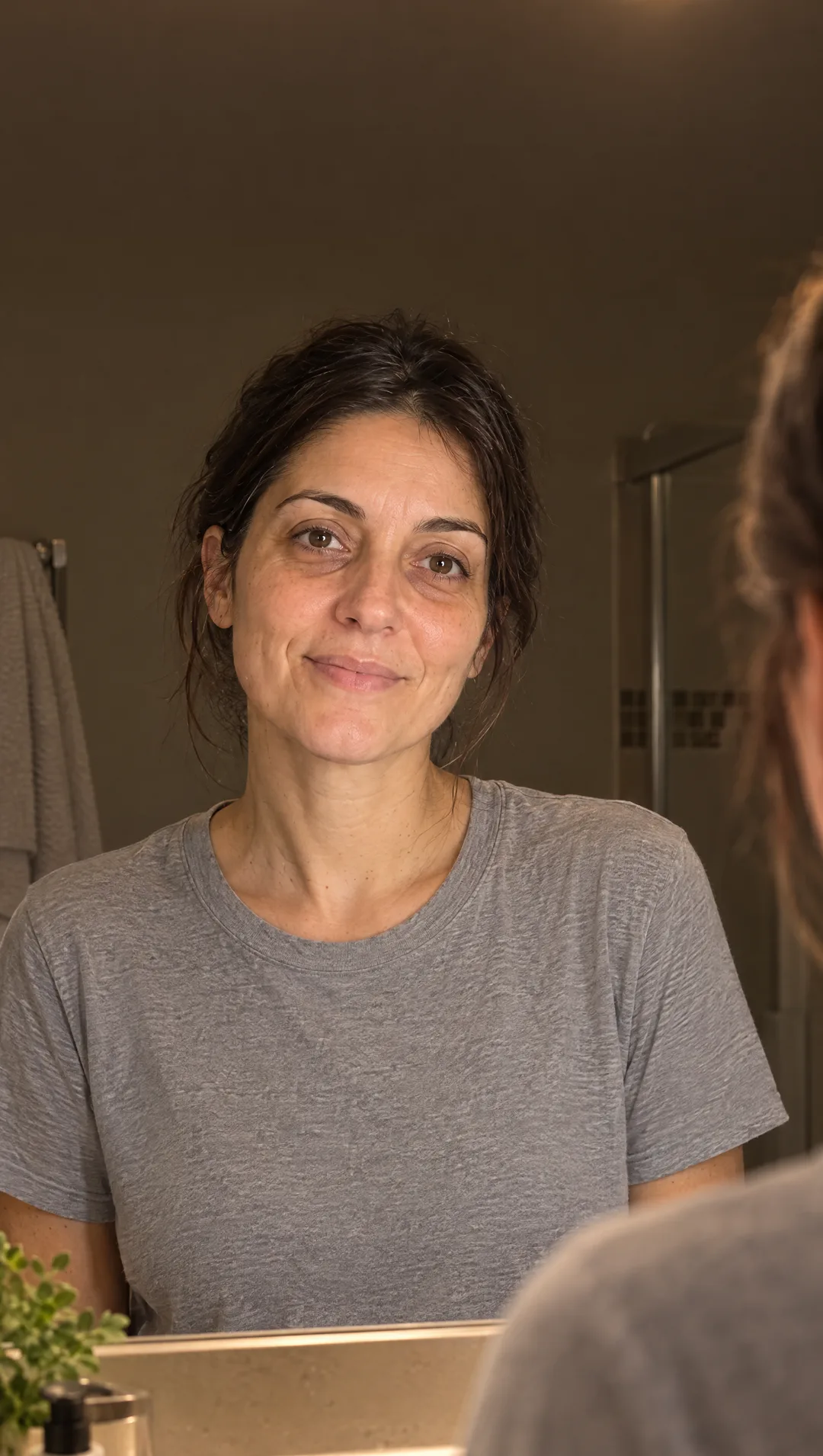 Elena alle 6:30 davanti allo specchio del bagno, la faccia riposata